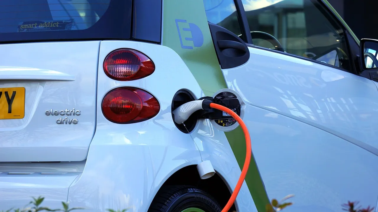 Witte elektrische auto die wordt opgeladen met een oranje laadkabel